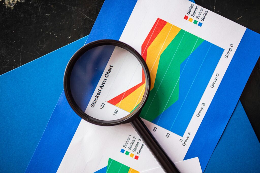 Magnifying glass highlighting stacked area charts for business analysis.